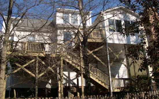 Second Level Sunroom, Three Levels of Deck, Stairs with Railings to Each Level and the Ground.