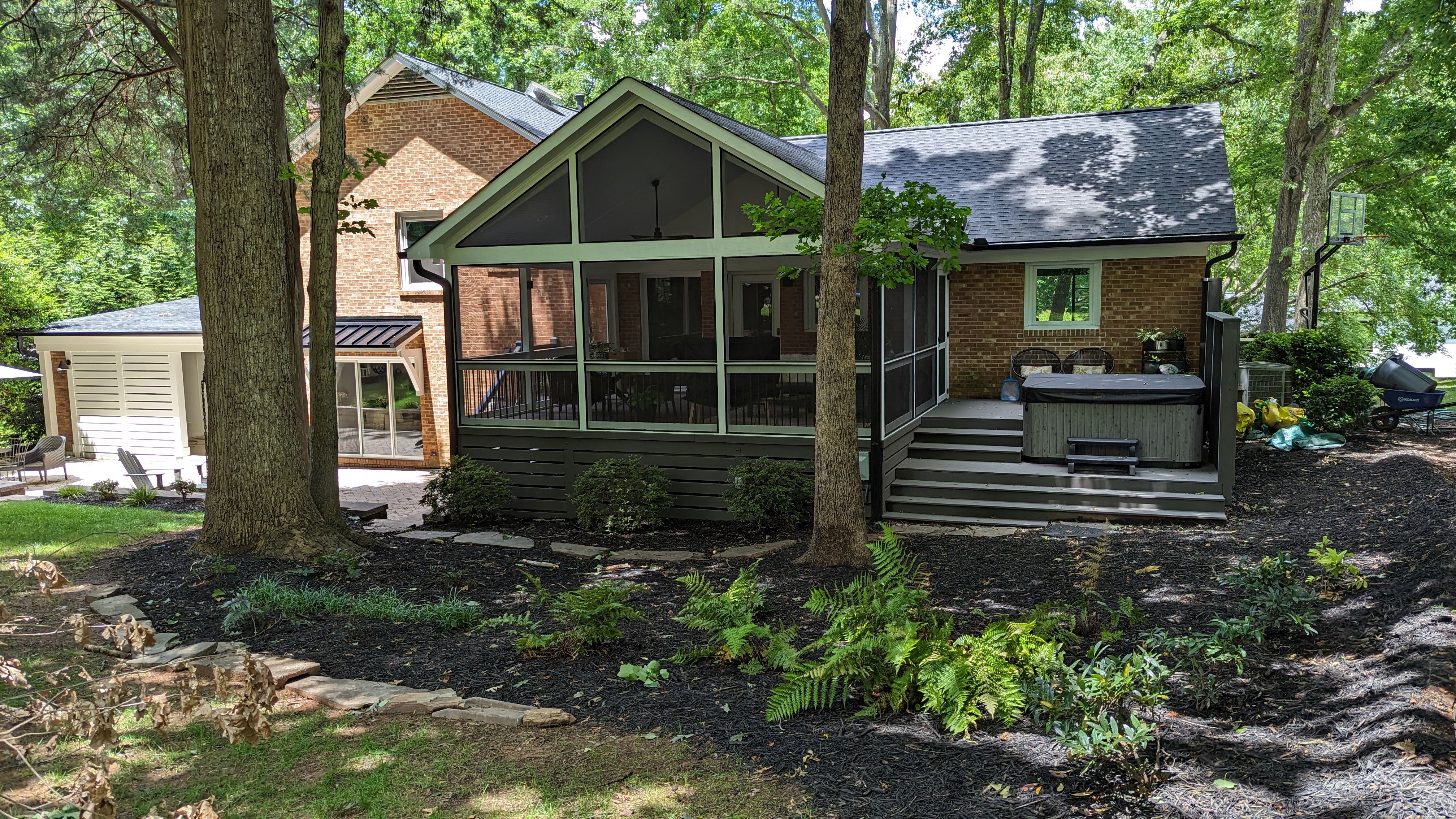 A gabled screen porch opens to an adjoining spa deck, broad steps and a privacy screen.