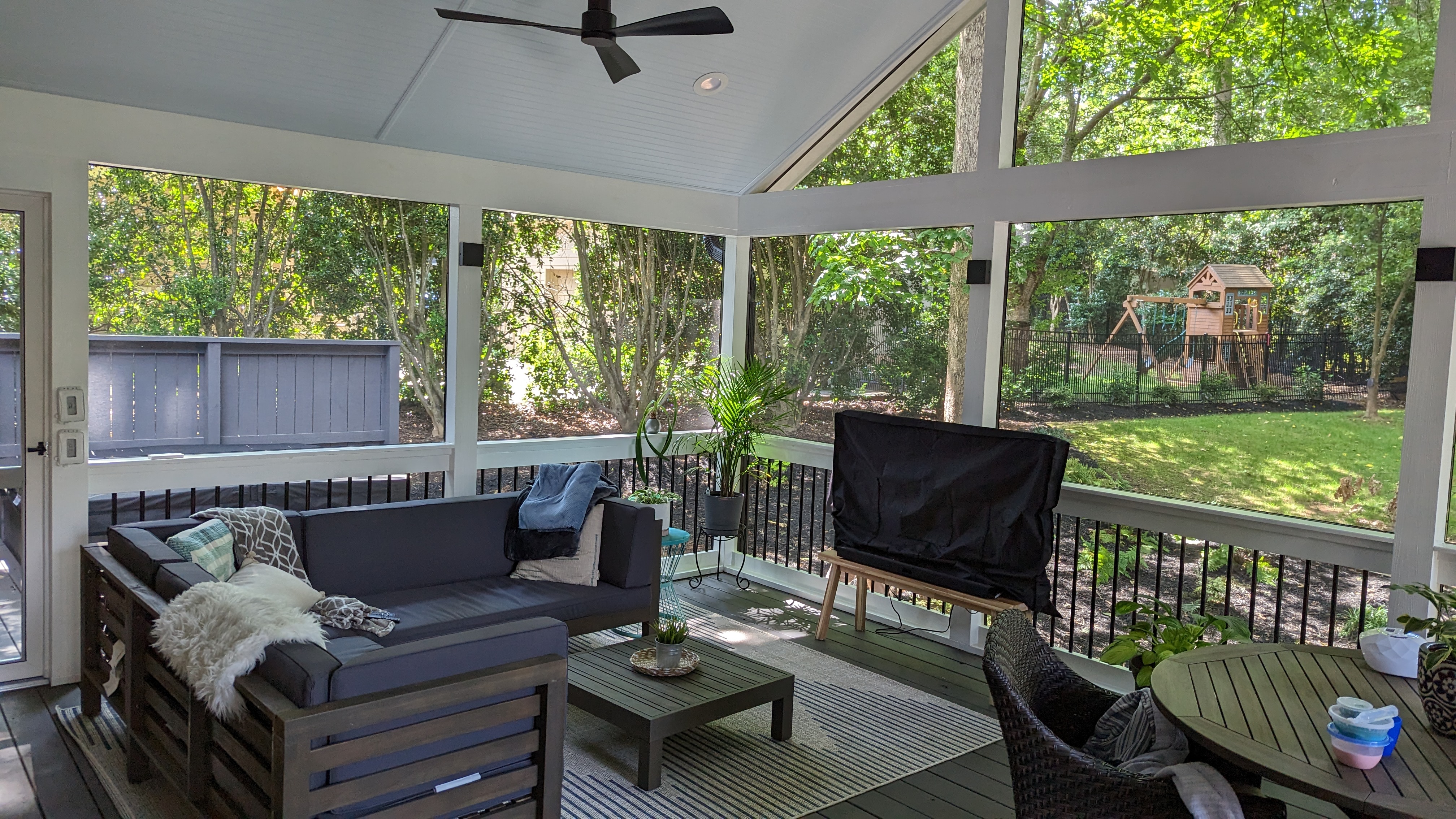 A vaulted ceiling, ceiling fan, comfortable seating and a dining area make the screened porch a welcoming place to gather.