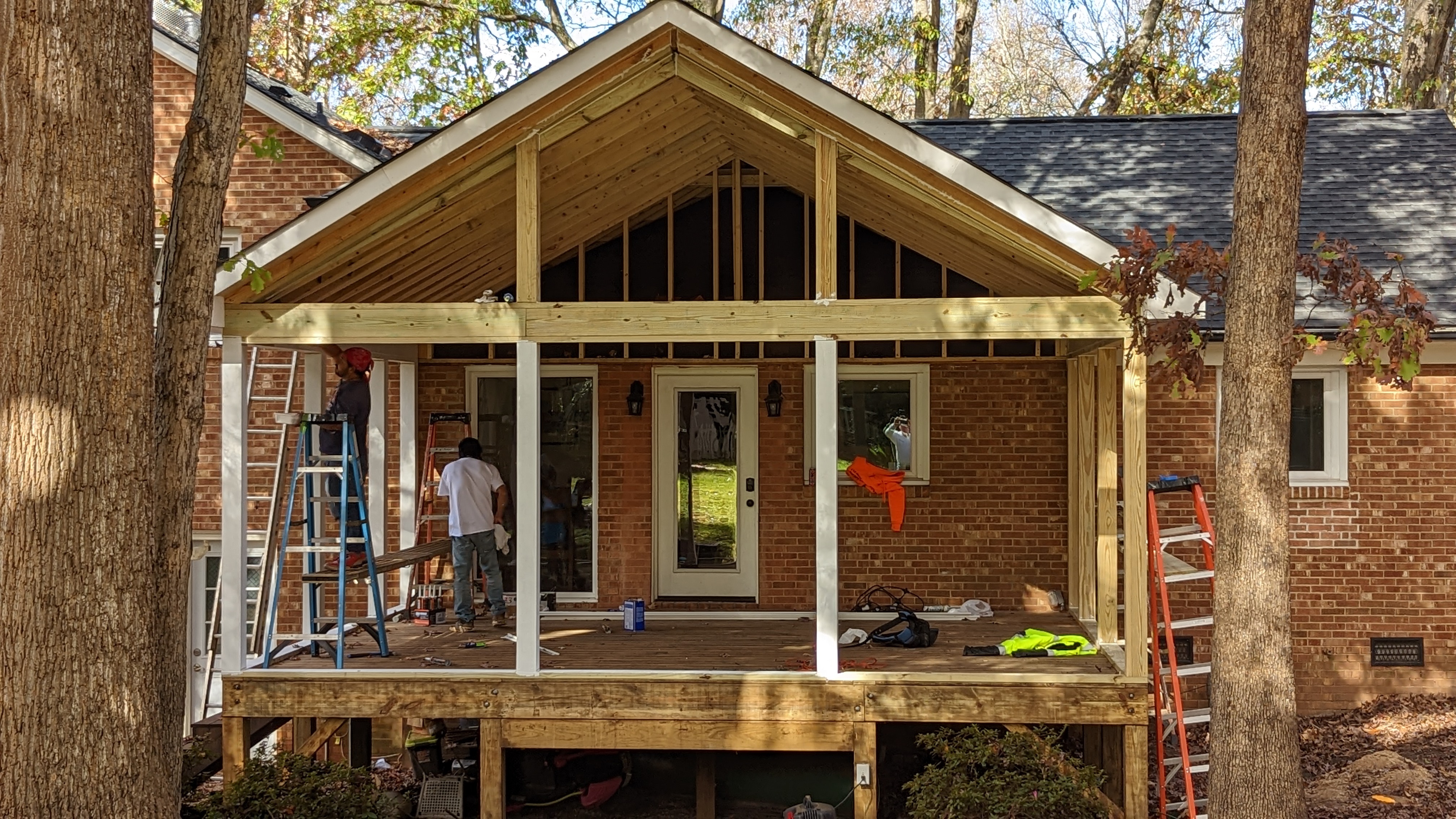 The porch’s gabled roof structure takes shape above the deck.