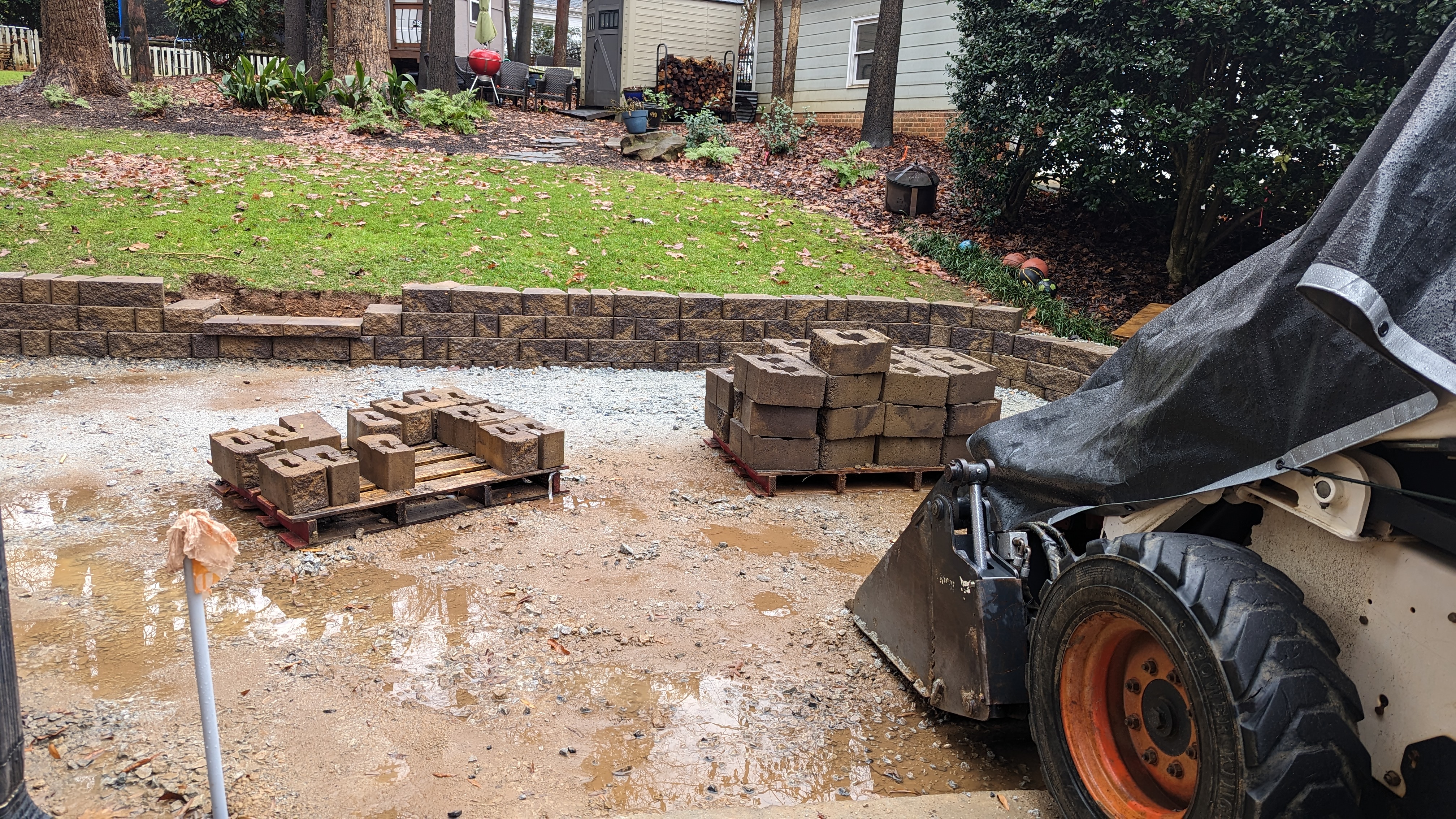 Excavation prepares the grade beside the house for the patio and retaining wall.