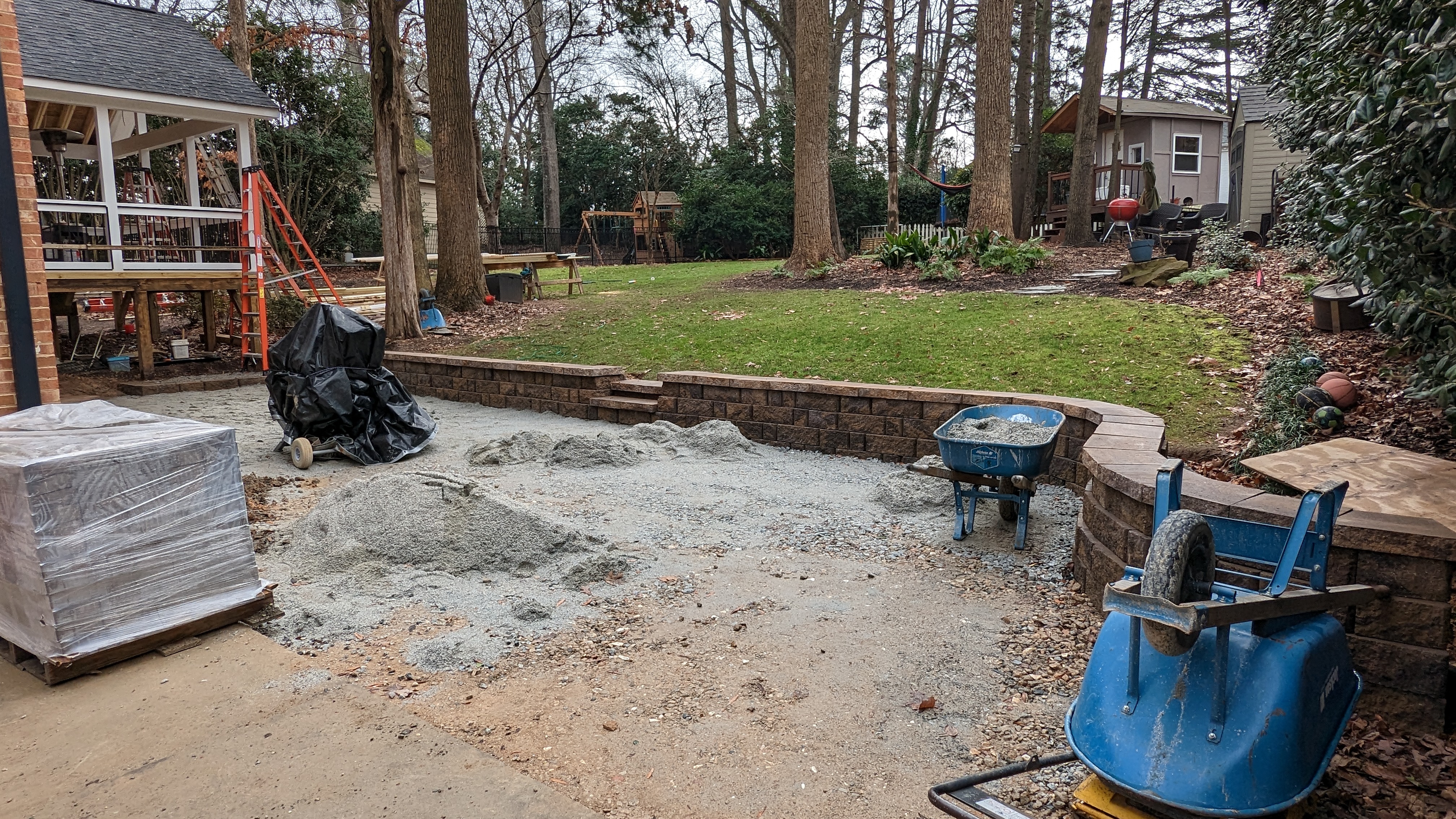The retaining wall and prepared base define the patio’s footprint.