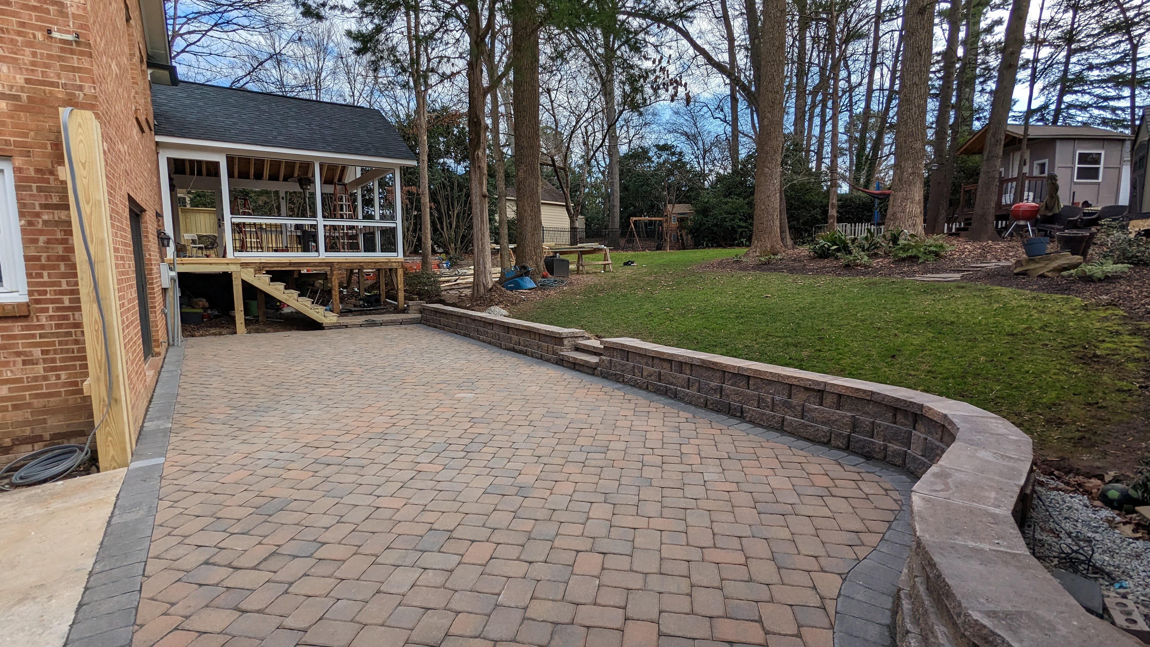 Stone pavers fill the patio inside the curved retaining wall.