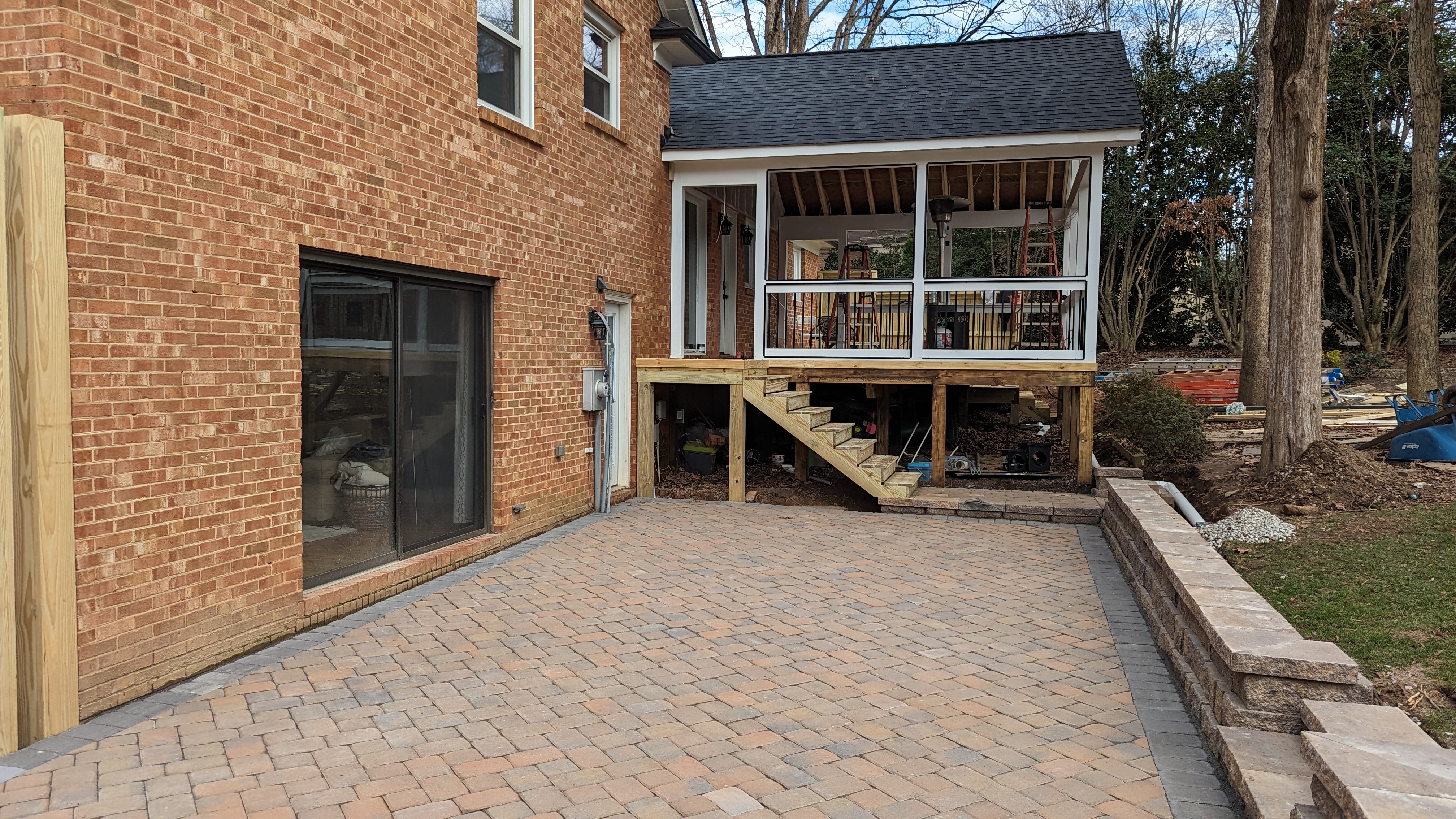 New porch stairs meet the stone paver patio.