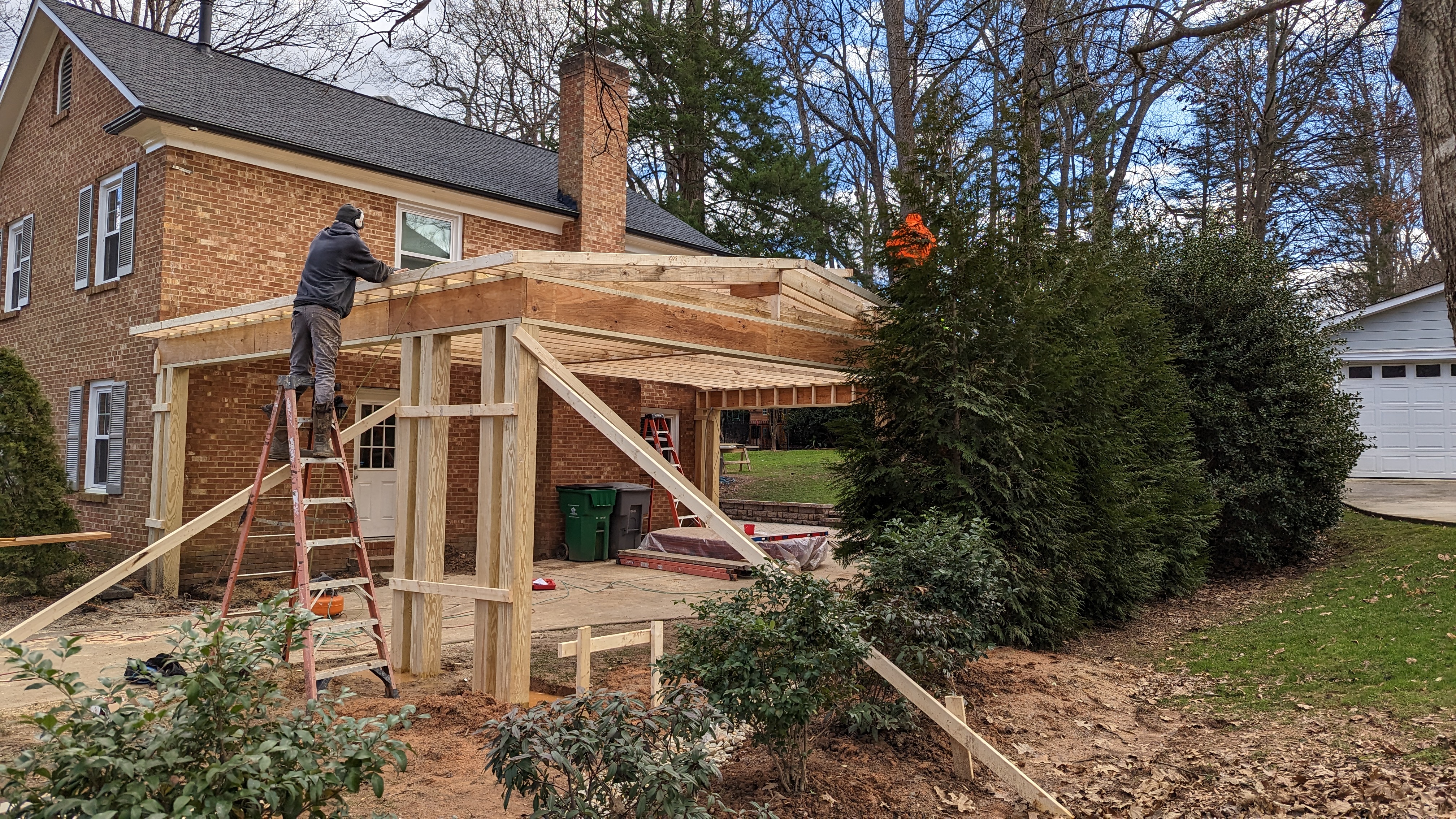 The crew frames the carport roof alongside the original house.