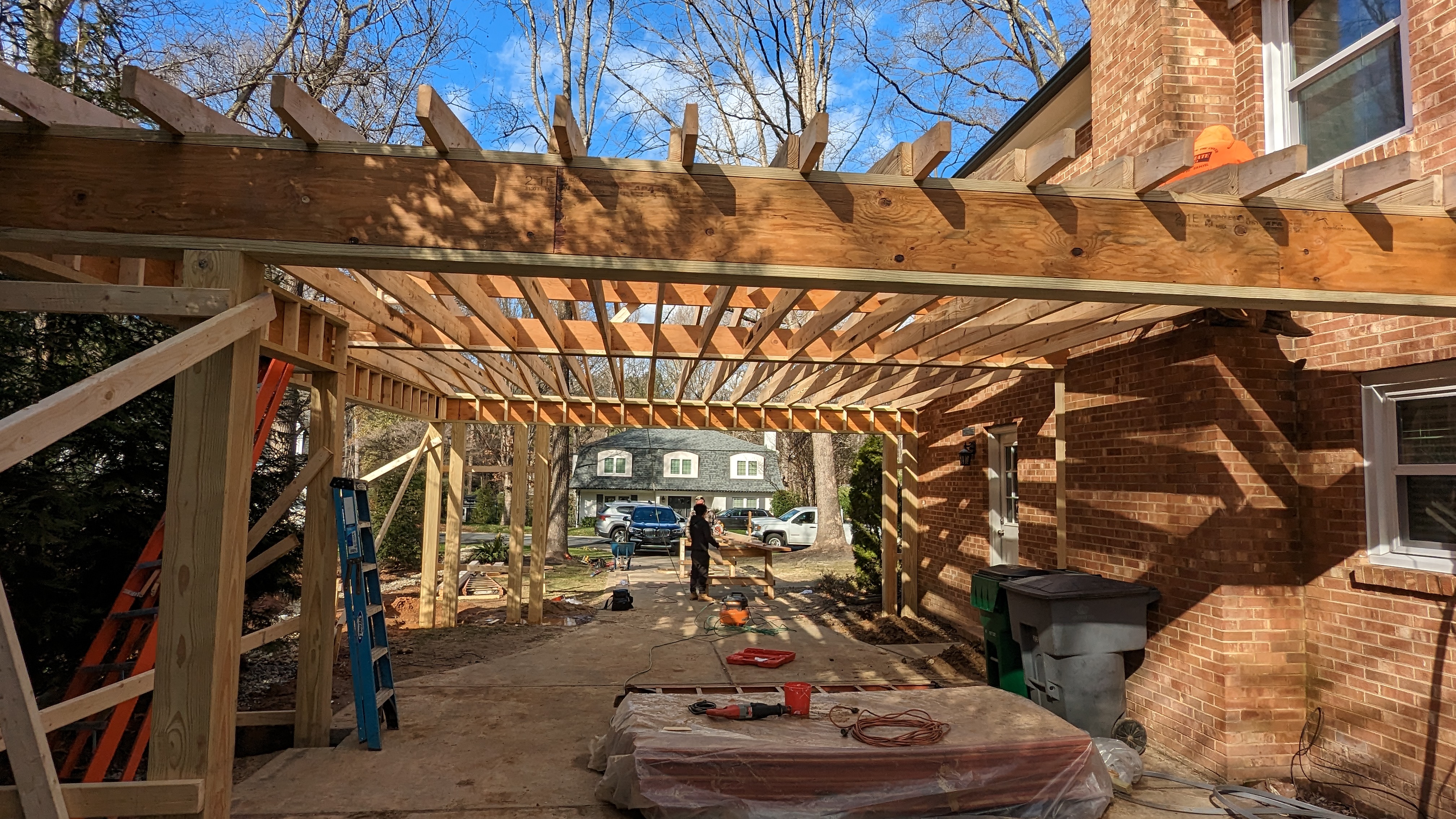 Open roof framing shows the structure behind the carport’s low profile.