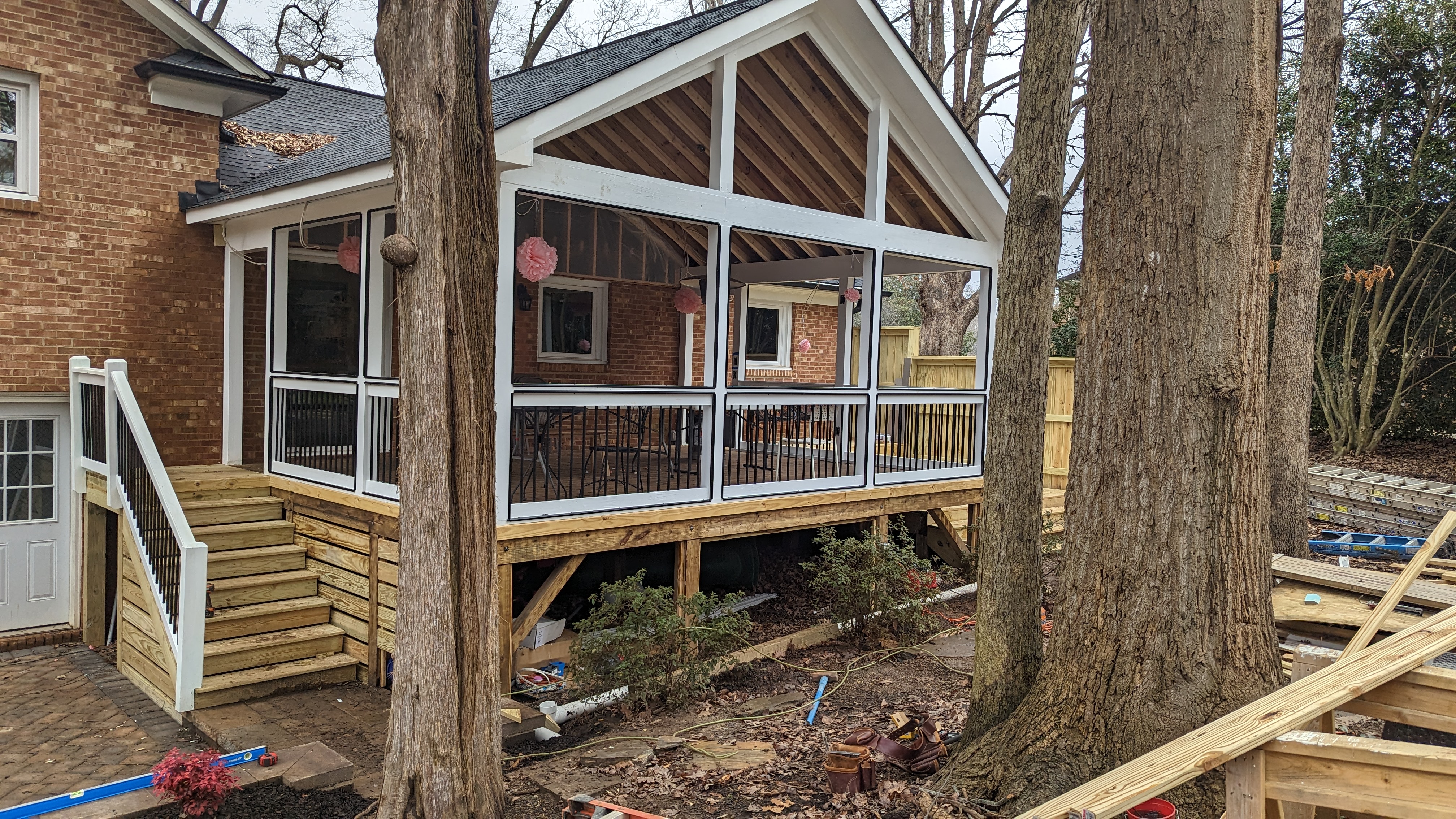 Porch stairs and railings connect the elevated room to the patio.