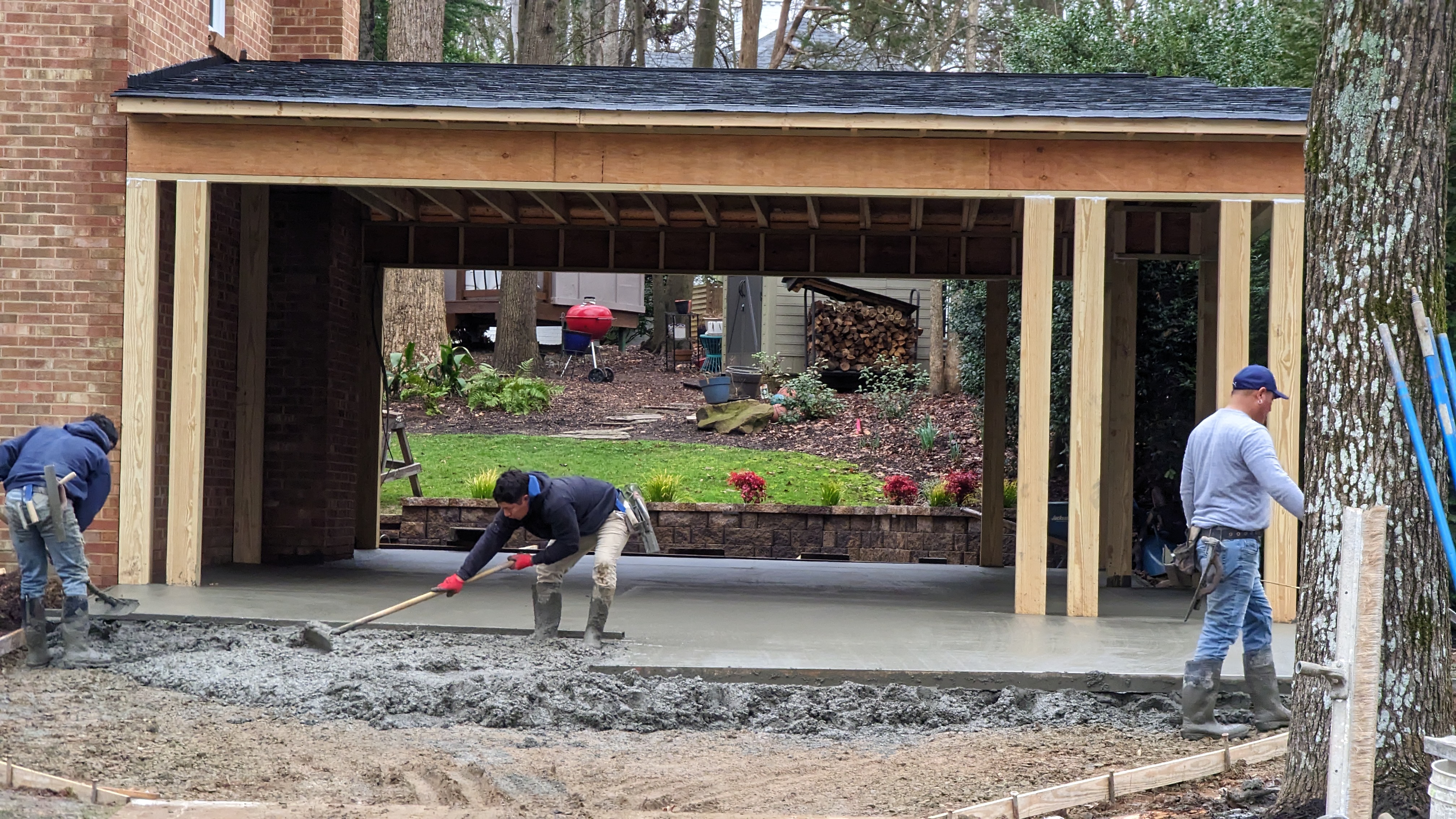 Fresh concrete is finished beneath the carport roof.