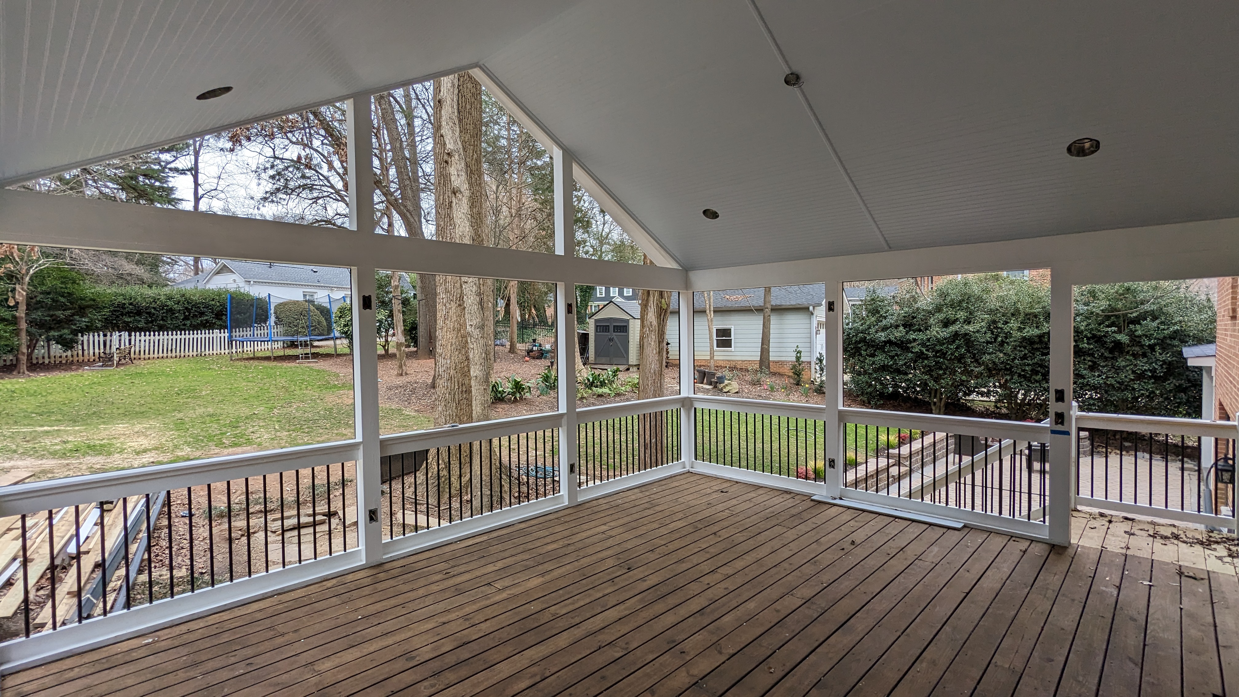 The white porch ceiling and dark balusters are in place as finishing continues.