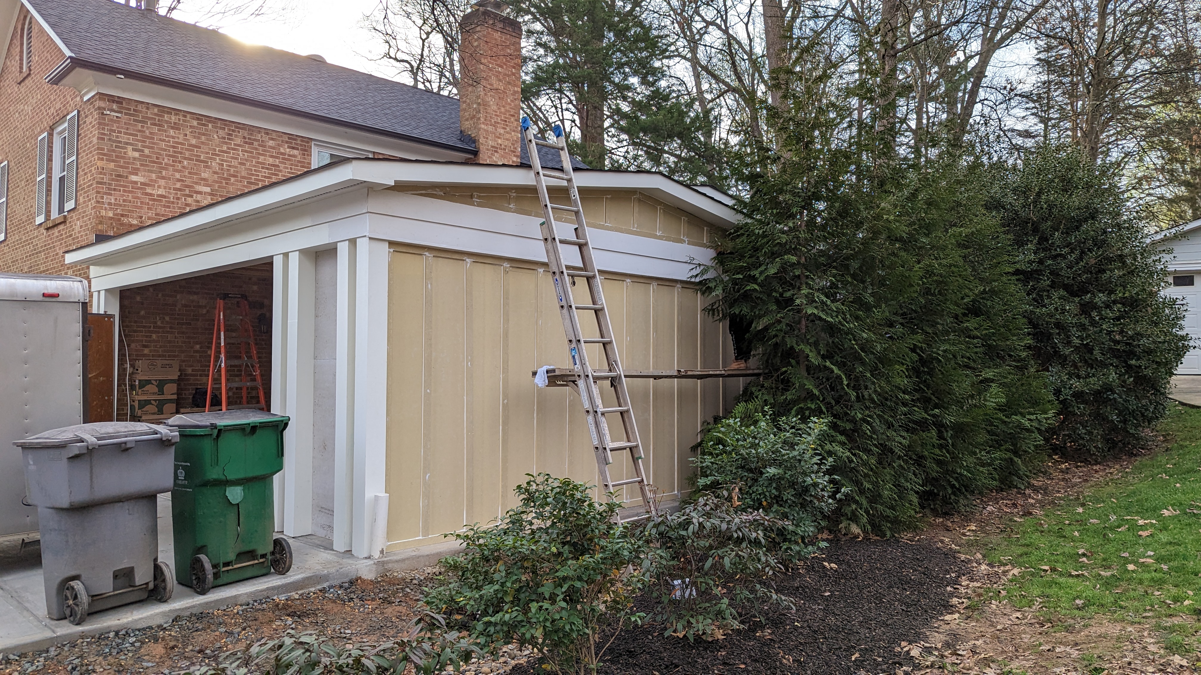 Carport siding and trim are finished around the new storage area.