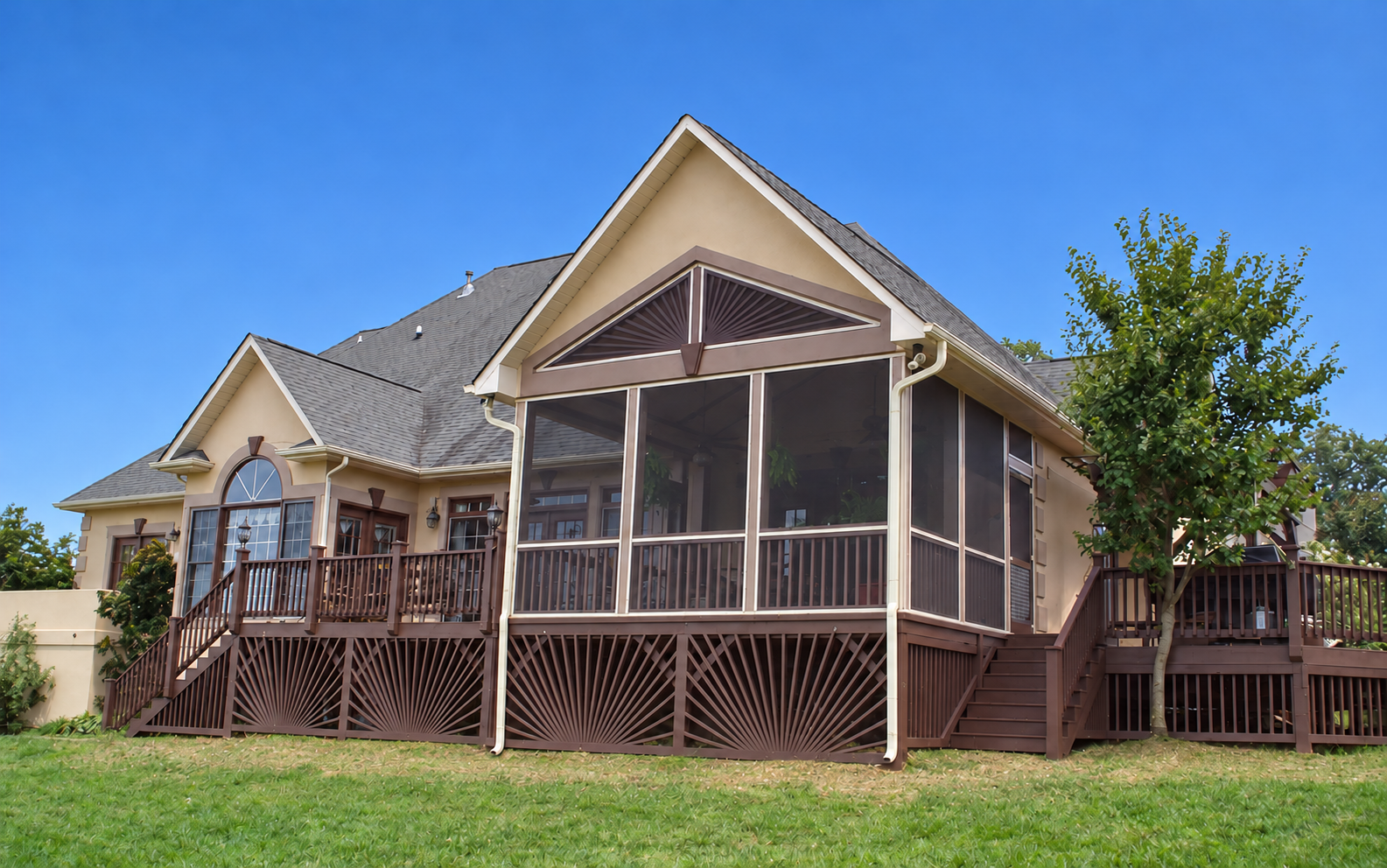 Completed stucco screened porch with a gable roof, deck and decorative skirting.